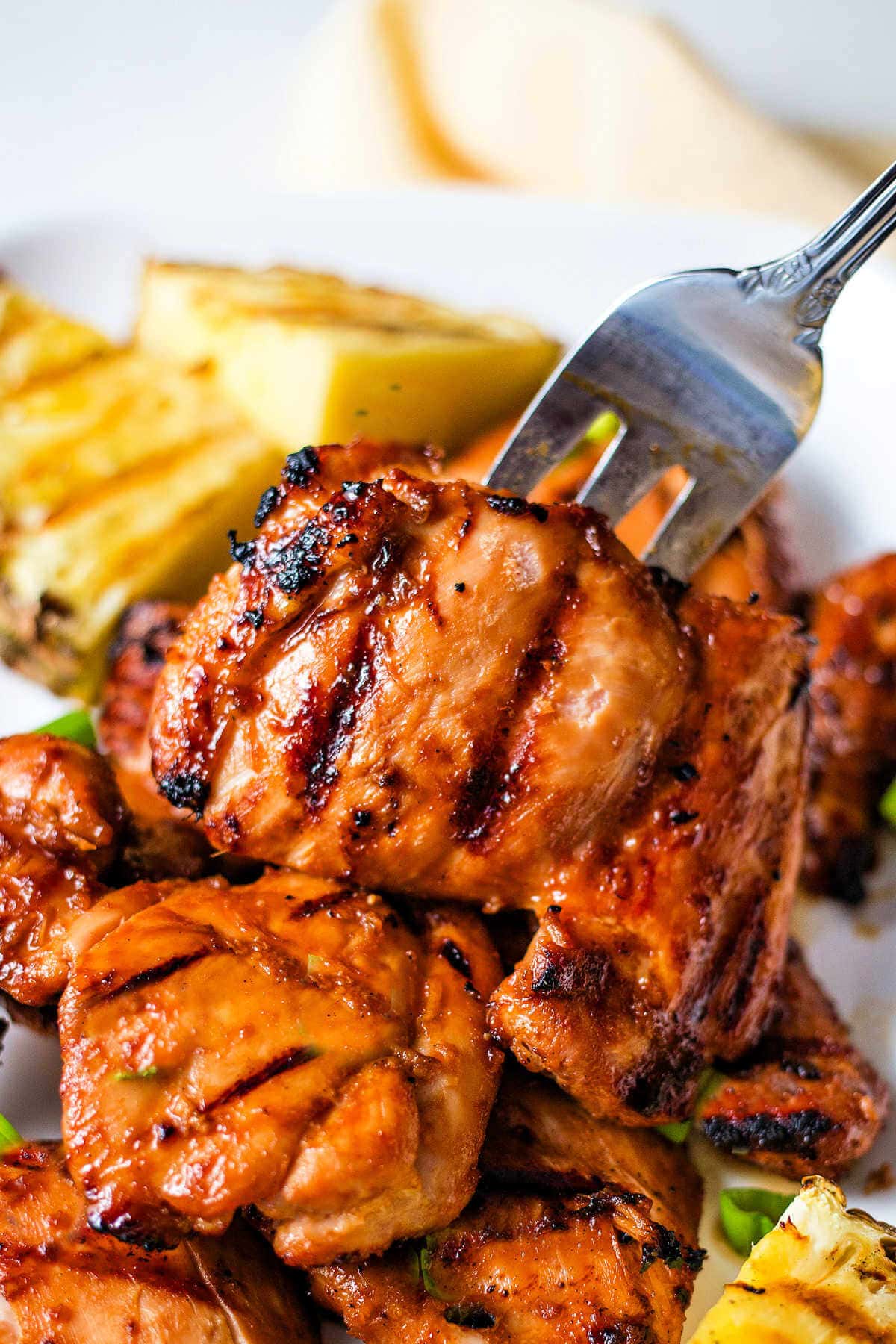 Fork picking up a piece of huli huli chicken.