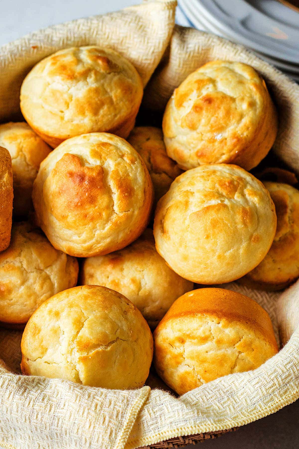 A dozen mayonnaise rolls in a basket.