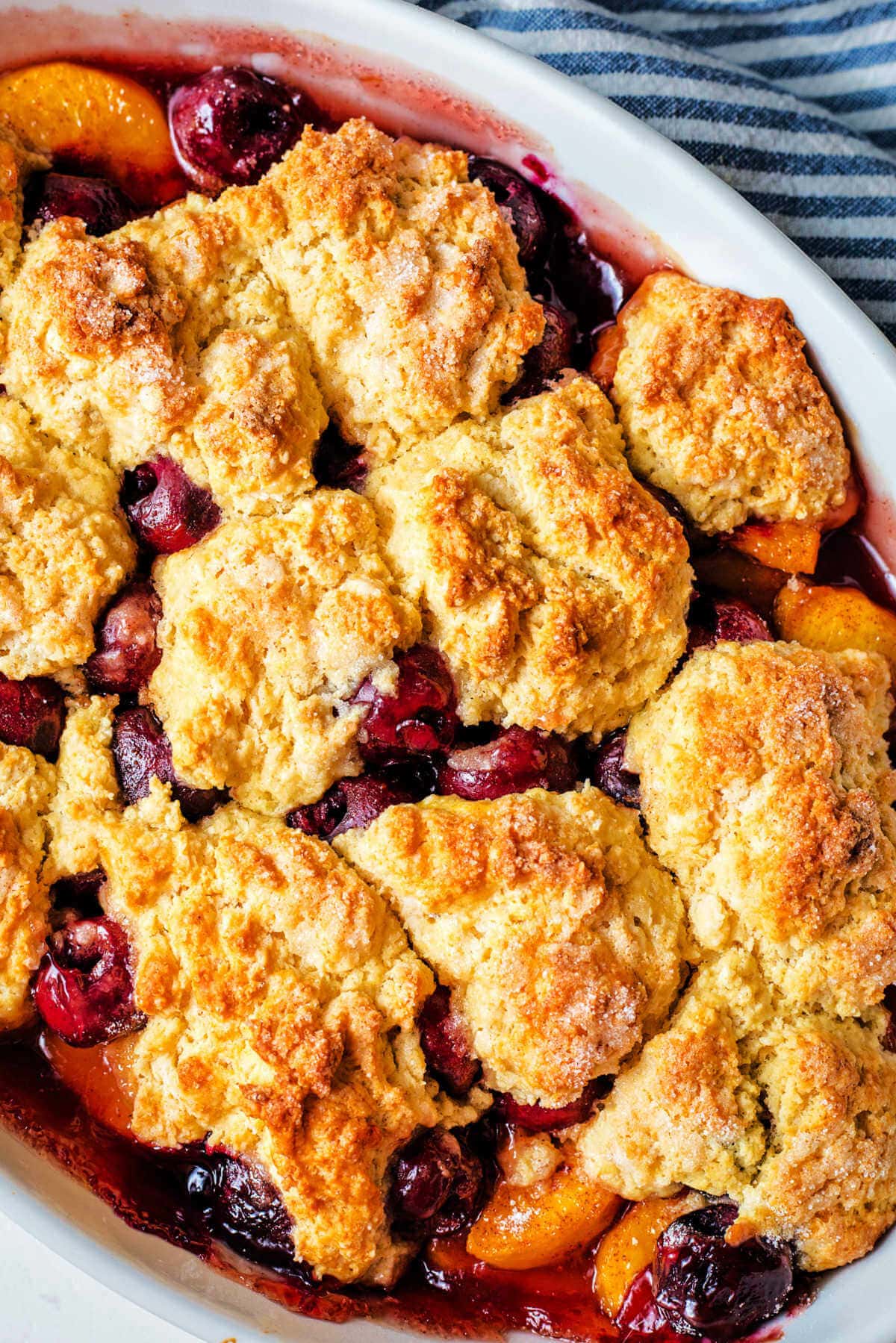 Overhead shot of a baked peach cherry cobbler.